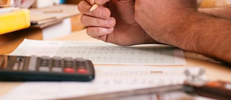 Mand holder blyant lommeregner skrivebord .jpg