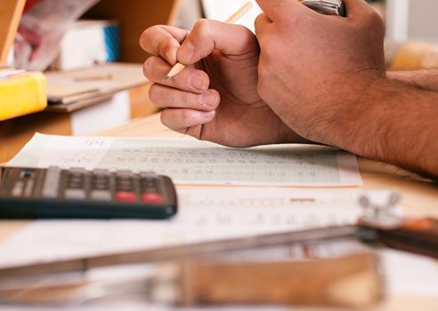 Mand holder blyant lommeregner skrivebord .jpg